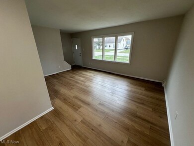 Spare room with baseboards and light wood-type flooring
