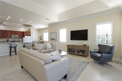 Tiled living room with a tray ceiling and a healthy amount of sunlight