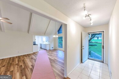 The entry has a storm door and tile floor. You can glimpse into the great room and kitchen