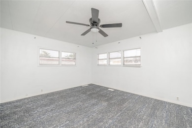 Empty room featuring carpet and ceiling fan