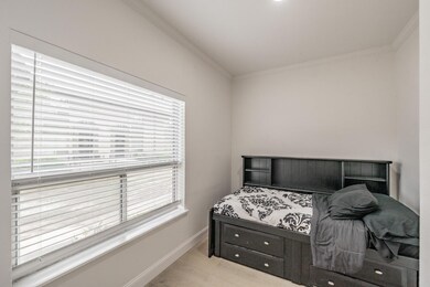 Bedroom featuring baseboards, crown molding, wood 