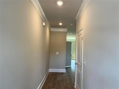 Hallway featuring dark wood-type flooring, baseboa