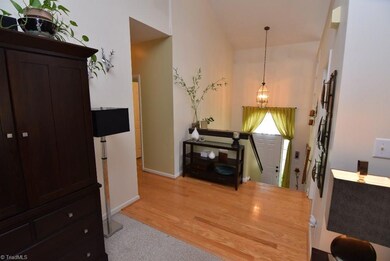 Bright and welcoming foyer has high ceilings and hardwood floors.