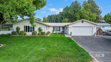 Ranch-style home with a front yard, driveway, and an attached garage