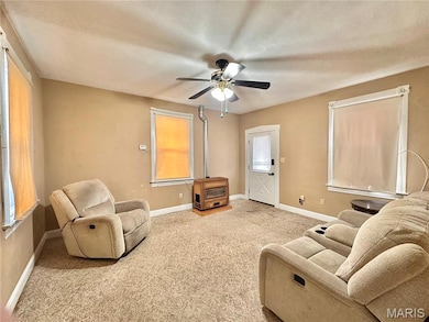 Living room featuring carpet, healthy amount of natural light, and ceiling fan