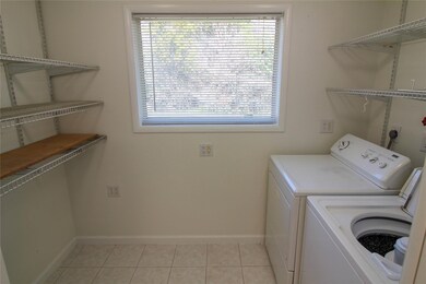 Clothes washing area featuring baseboards, washer