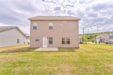 Rear view of property featuring a patio and a lawn