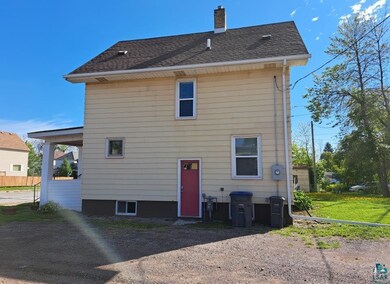 Rear view of house featuring a yard
