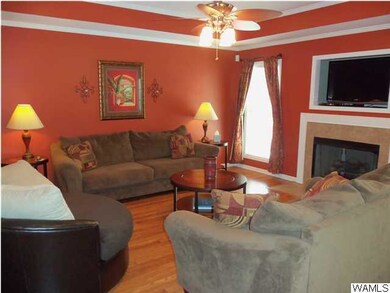 Spacious den with tray ceilings, fireplace, and en
