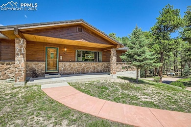 View of front of home featuring stone siding and covered porch