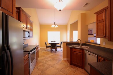 Full view of the kitchen with its beautiful stacked cabinets and abundant counter space with bar seating.