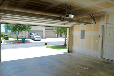 Garage with electric panel and a garage door open