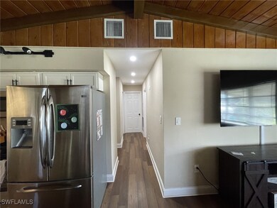 Kitchen featuring lofted ceiling with beams, white