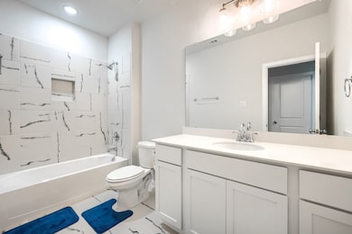 Full bath with  shower combination, vanity, and light tile patterned flooring