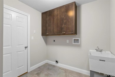 Laundry area featuring cabinets, hookup for a washing machine, hookup for an electric dryer, and sink