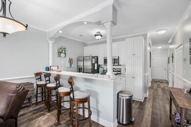 Kitchen with white cabinetry, crown molding, backs