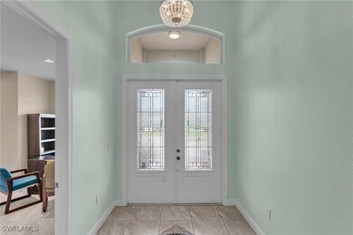 Entrance foyer with french doors and a chandelier