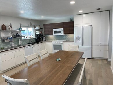 Kitchen featuring modern cabinets, a sink, open s