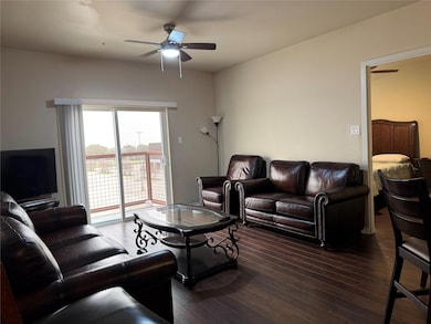 Living area with ceiling fan and wood finished flo