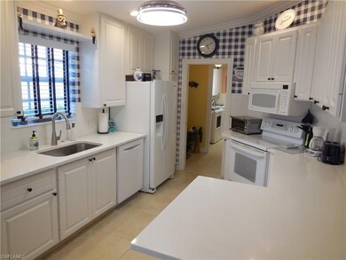 Kitchen with sink, white cabinetry, white applianc