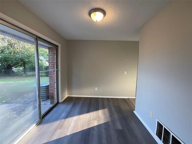 Spare room with a textured ceiling and dark hardwo