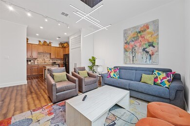 Living area featuring wood finished floors, rail lighting, and ornamental molding