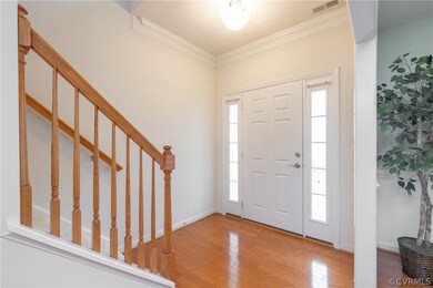 Foyer featuring ornamental molding, wood-type floo
