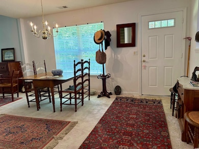 Foyer with a chandelier and light colored carpet
