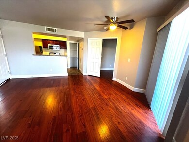 Unfurnished living room featuring dark wood-style flooring and ceiling fan
