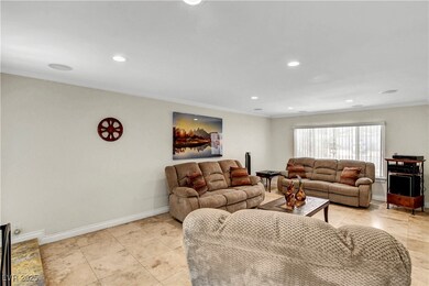 Living area with ornamental molding, baseboards, r