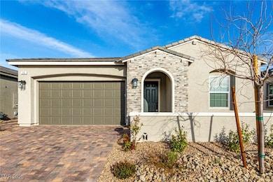 View of front of house with decorative driveway, a