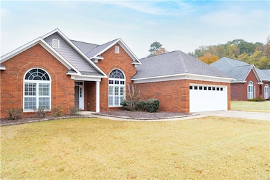 Traditional-style home with brick siding, a front lawn, and driveway