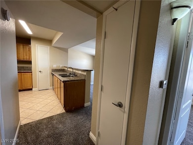 Kitchen featuring brown cabinets, light tile patte