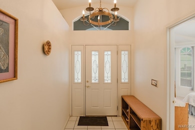 Foyer with light tile patterned floors, lofted cei