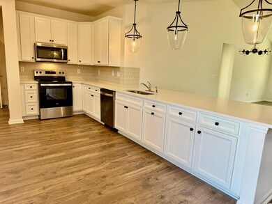 Kitchen featuring a sink, light countertops, a pen