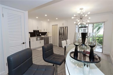 Dining room featuring a chandelier, light wood-style flooring, crown molding, and recessed lighting