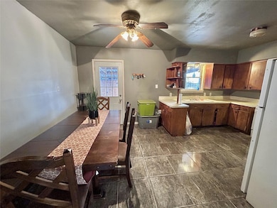 Kitchen with brown cabinets, light countertops, ce
