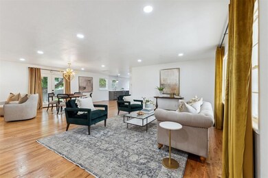 Living room with recessed lighting, light wood finished floors, and a chandelier