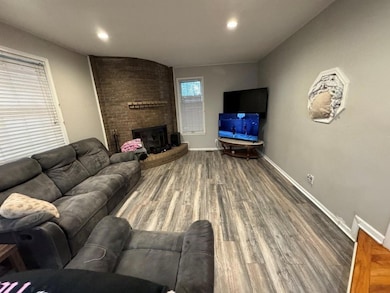 Living room with wood finished floors, a fireplace, and recessed lighting