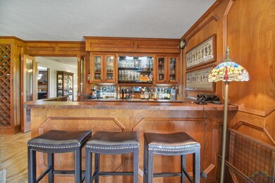 Indoor wet bar featuring crown molding, wood walls, and a textured ceiling