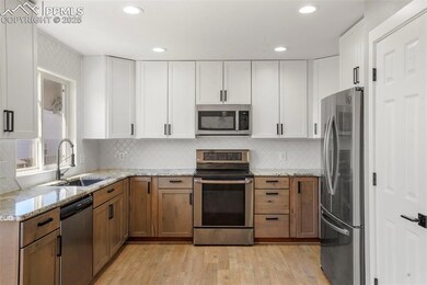 Kitchen featuring light stone counters, sink, whit