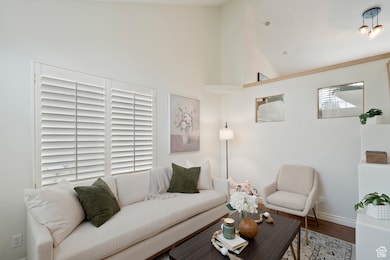 Living area with wood finished floors and high vaulted ceiling