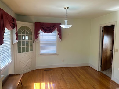 Unfurnished dining area featuring hardwood / wood-style floors and baseboards