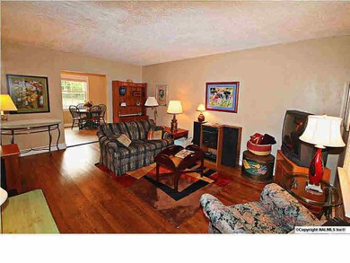 HARDWOOD FLOORING WARMS THE LIVING ROOM AND FLOWS INTO BEDROOMS 1 & 2.