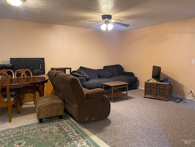 Living room featuring a textured ceiling, carpet, an office area, and ceiling fan