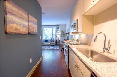 Kitchen with stainless steel appliances, dark hardwood / wood-style flooring, white cabinets, sink, and backsplash