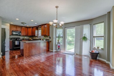 Eat in kitchen with hardwood floors, counter seating, walkout to patio and private yard.