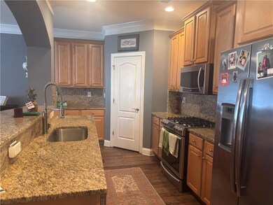 Kitchen with dark wood-style flooring, stainless s