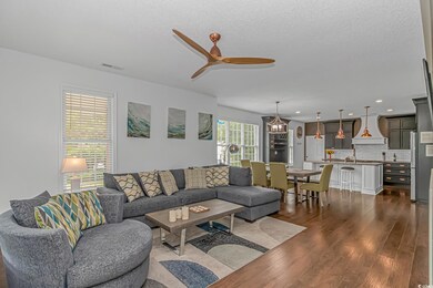 Living area featuring a ceiling fan, dark wood-style flooring, and recessed lighting