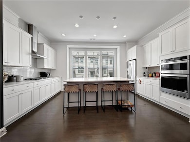 Kitchen with stainless appliances, range hood, a b